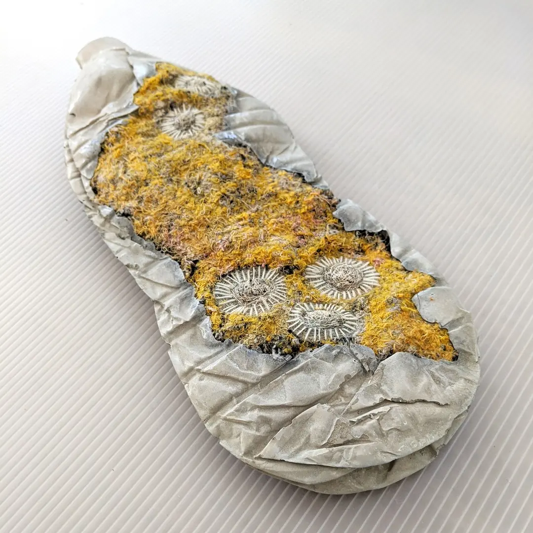 Plastic bottle with yellow embroidered plant growing on